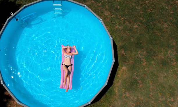 有吸引力的金发女人漂浮在气垫上的俯视图图片下载