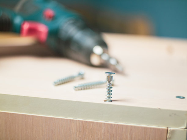 家具螺丝和螺丝起子以公寓内的组合家具为背景。图片下载