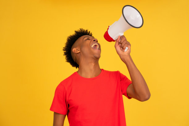 一个用扩音器提高声音的非洲男人。图片下载