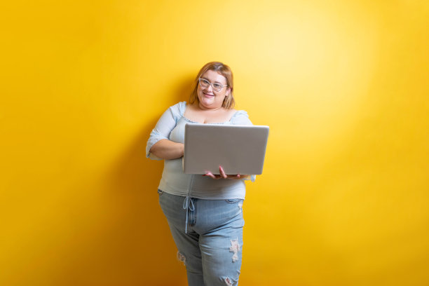 胖胖的年轻白人模特拿着笔记本电脑图片下载