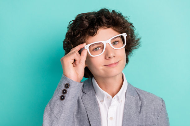 照片中甜美自信的男生穿着灰色西装，戴着微笑孤立的蓝绿色背景图片下载