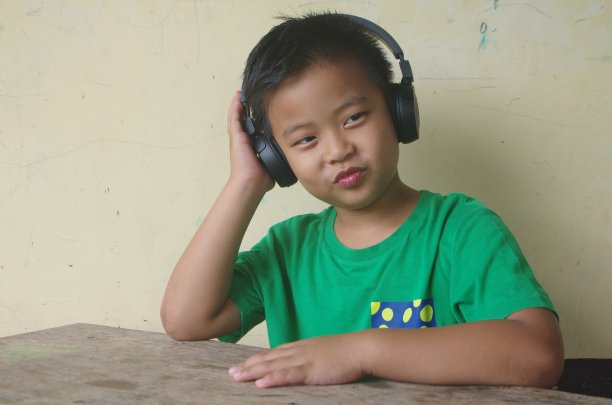 这个男孩通过无线耳机听音乐。图片下载