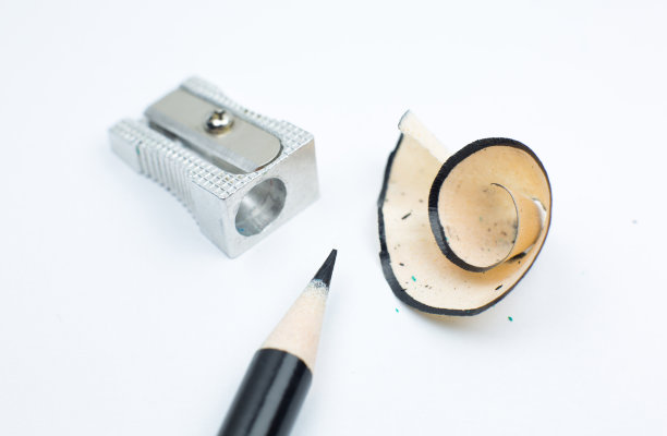 卷笔刀和断了的铅笔。白色背景上的刨花和石墨。特写，微距照片。回到学校的概念。图片下载