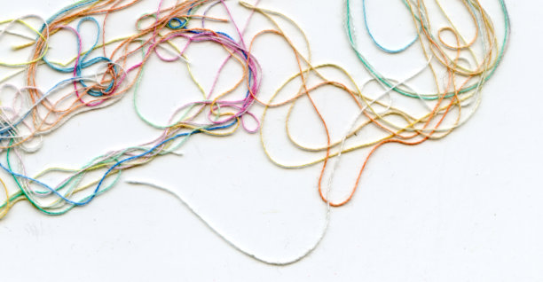 多色纠结彩色绣花丝线。抽象色彩背景，以白色为背景图片下载