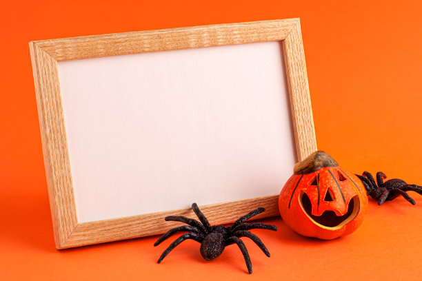 装饰橙色小微笑万圣节南瓜模板模板白色框架木制边界和黑色恐怖蜘蛛在橙色模糊的背景和复制空间。秋天节日的概念图片下载