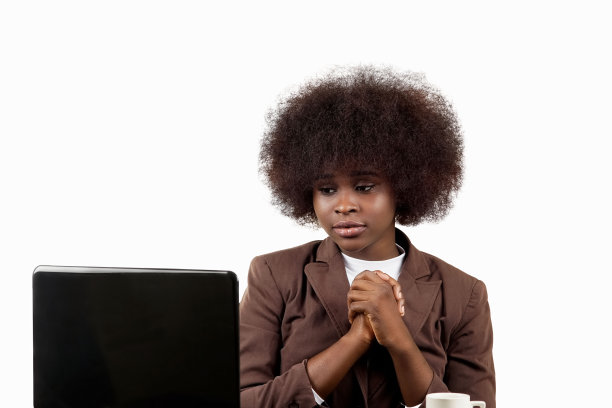 年轻的西班牙裔黑人女商人，留着非洲式的头发，用担心的姿势看着她的笔记本电脑，背景是白色的图片下载