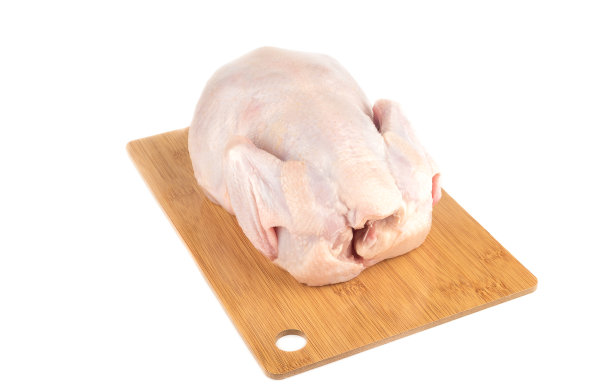 生的全鸡放在白色背景的木制砧板上。图片下载