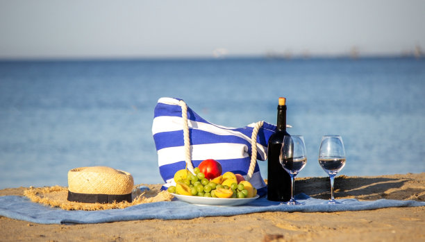 野餐毯，美酒，水果，美丽的海滩。有选择性的重点图片下载