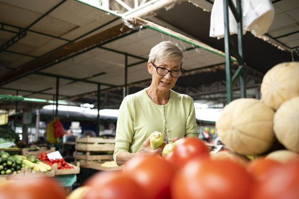 高加索妇女的肖像购买新鲜的有机蔬菜和水果在市场和持袋的健康食品。图片下载