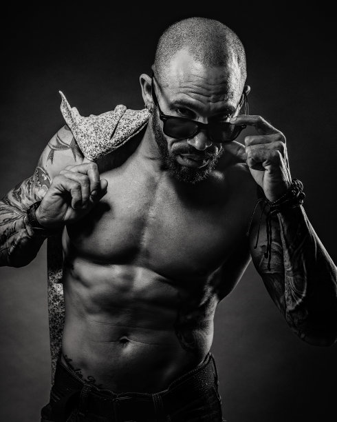 黑色和白色的肖像男子赤裸的躯干从眼镜下看。工作室的照片。肌肉的身体图片下载