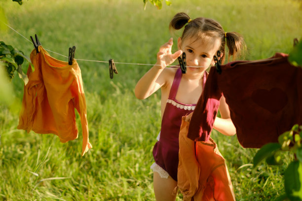 女孩伸手到晒衣夹上晒衣服图片下载