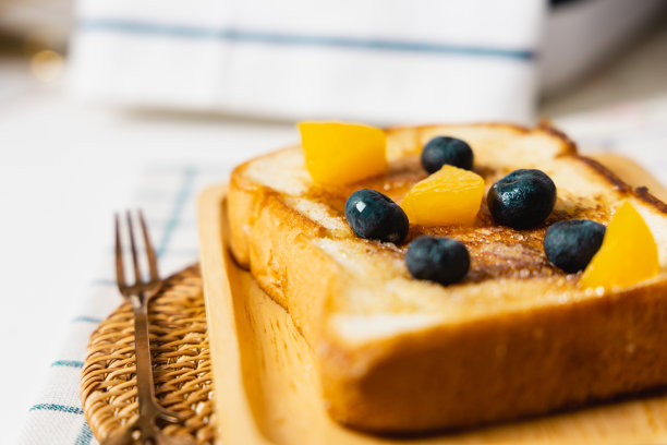 法式吐司，配上蜂蜜糖浆和木制盘子上的蓝莓图片下载