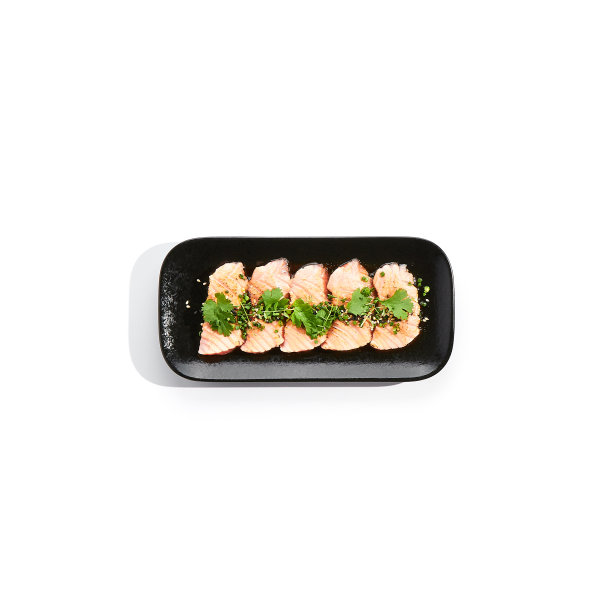 三文鱼寿司——烤三文鱼，切成薄片的生鱼片。三文鱼寿司配上美味的柑橘汁和新鲜的蔬菜。日本海鲜在黑色盘子孤立在白色背景。图片下载