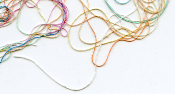 多色纠结彩色绣花丝线。抽象色彩背景，以白色为背景图片下载