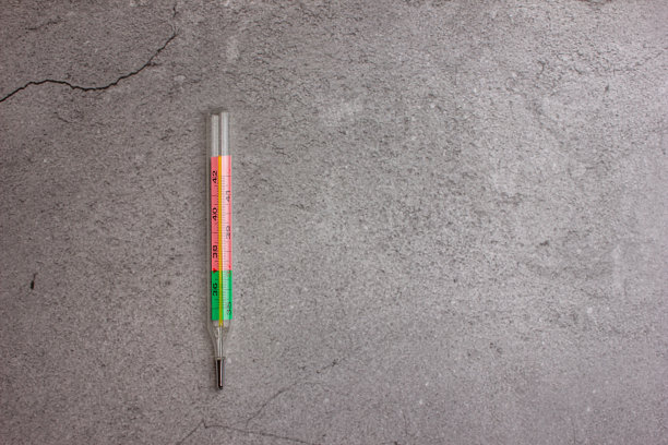 花岗岩底座上的水银温度计。灰色背景上的酒精温度计。图片下载