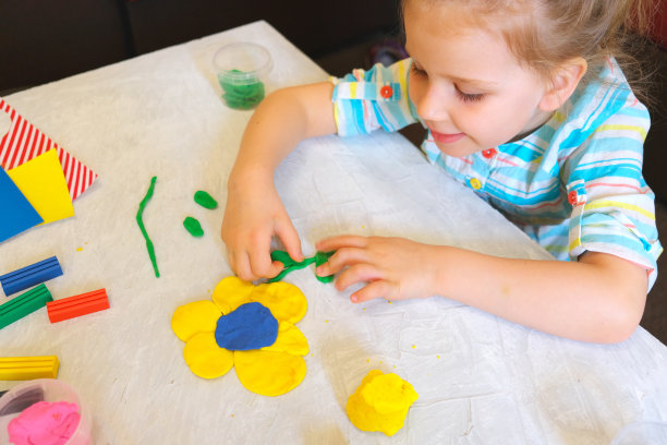 小女孩用橡皮泥做花，用粘土做家庭教育游戏。图片下载