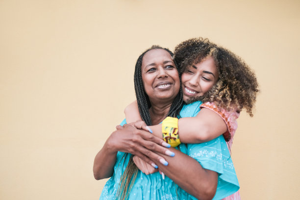 非洲成年女儿穿着传统服装拥抱母亲-家庭之爱图片下载