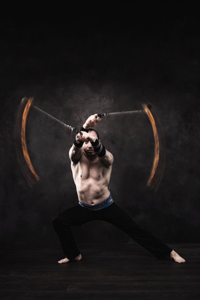 在摄影棚里表演火表演的杂技演员。图片下载