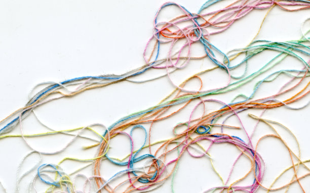 多色纠结彩色绣花丝线。抽象色彩背景，以白色为背景图片下载