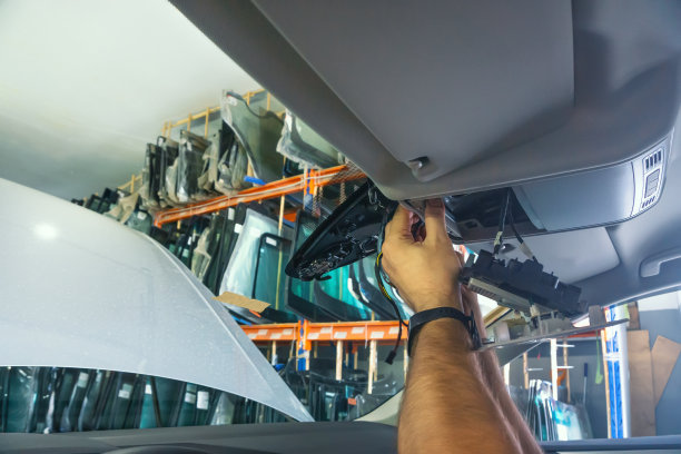 汽车修理。维修人员修理车内电线。用断开传感器更换挡风玻璃图片下载