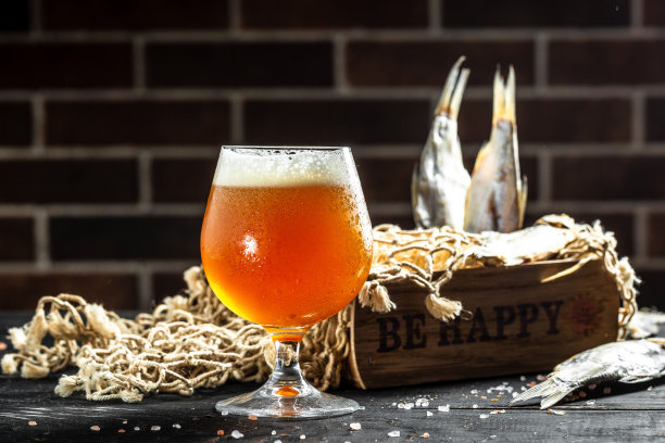 啤酒和厚厚的泡沫和晒干鱼在木制背景。横幅，菜单，食谱的地方为文本图片下载