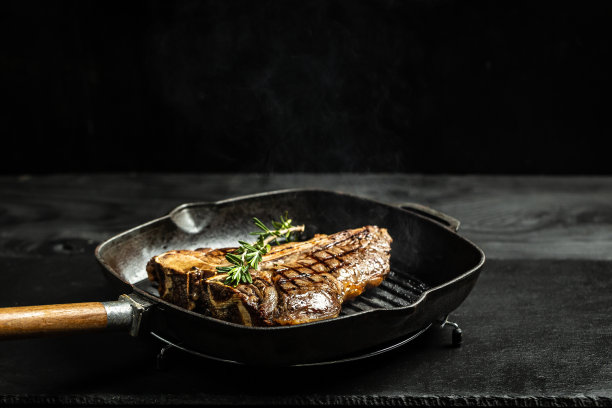 在黑色煎锅上煎牛排。餐厅菜单，节食食谱，食谱图片下载