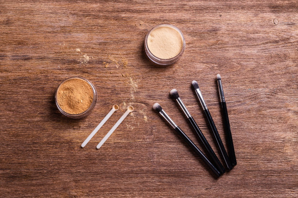 松散的粉状矿物粉末用于脸部和刷子用于木制背景上的粉末和面部。环保有机化妆品。图片下载