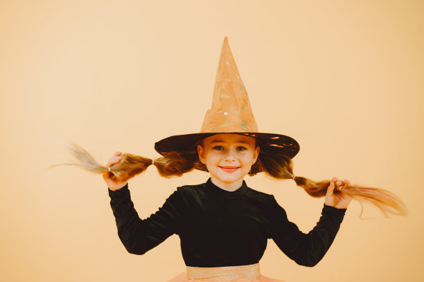 橙色背景下美丽的女巫女孩图片下载