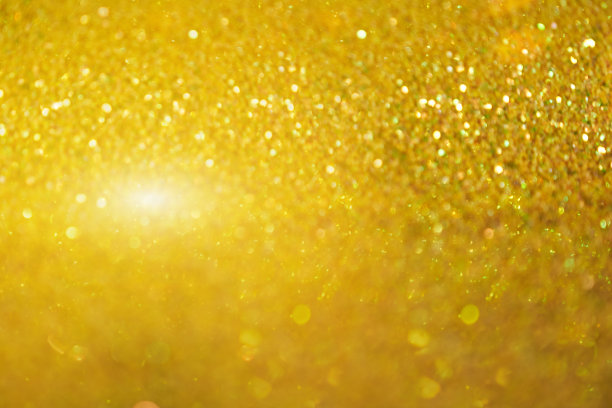 模糊的纹理的金色闪耀。背景有金色或黄色的亮片。无缝纹理与金黄色亮片。闪烁的背景图片下载