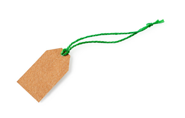空白纸板标签上的绿色黄麻丝带孤立在白色背景。空牛皮纸标签与亚麻线特写。可回收绳子标签的天然材料。副本的空间。图片下载