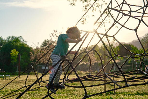 在操场上爬绳梯的孩子。图片下载