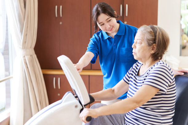 老年人在健身自行车上锻炼，有看护者在旁边看着图片下载