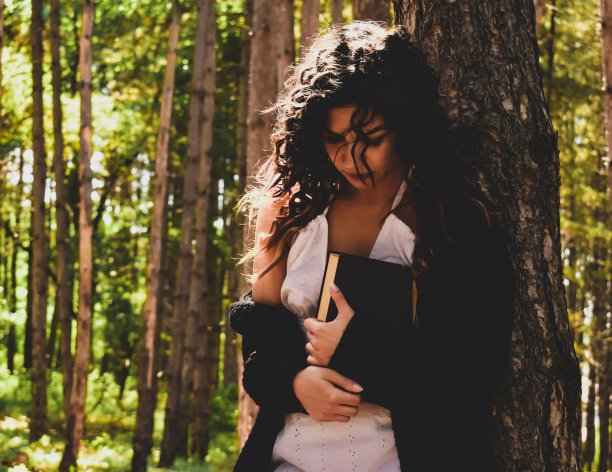 一个年轻女子在森林里寻找自我和知识，让她的精神自由漫游的库存摄影图片下载