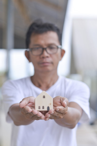 男人手里的玩具屋图片下载