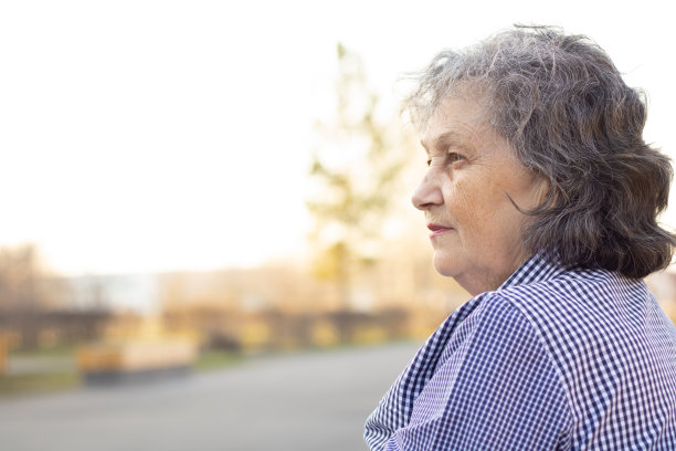 一位沉思的老妇人向一旁看了看。在概要文件。头发花白的祖母。图片下载