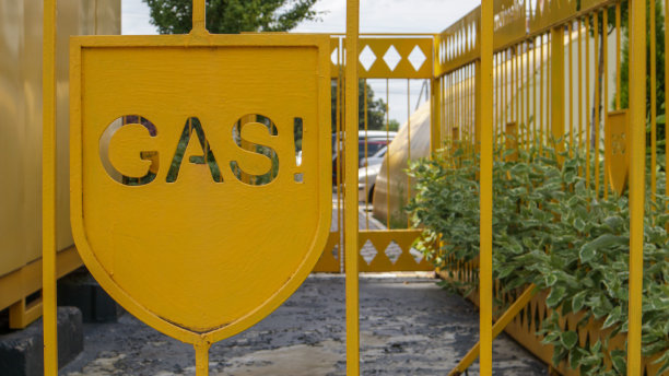 装有气体装置的金属笼警告市民。注意煤气管。题词用英文GAZ。地面安装中压气体管道黄色警告标志图片下载