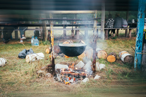 远足时准备户外食物。在火上的锅里煮鱼汤。图片下载