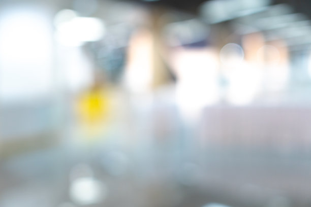 模糊洁净医院走廊抽象背景。在浅色地板的办公室走道视野模糊。白光大楼大厅离焦走道，病人登记在前台。图片下载