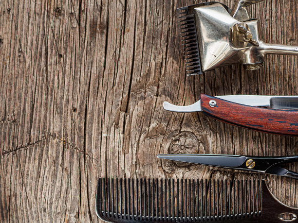 在一个旧的木头表面是旧的理发工具。复古手工理发剪，梳子，剃须刀，剃须刀图片下载