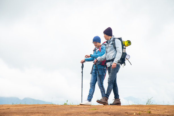两个亚洲男性朋友在山路上徒步旅行图片下载