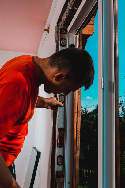 安装锁匠在固定好窗户后检查它是否固定在墙上，安装好窗户后，主人使用水平仪。图片下载