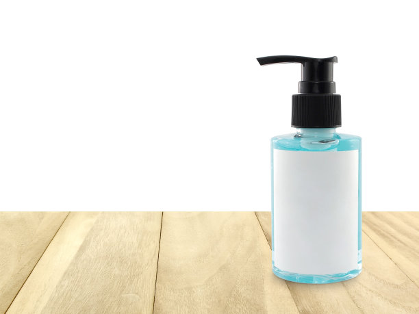 淡蓝色的洗手液，装在透明塑料瓶里，带泵盖，木桌上有空白标签，有白色的副本空间图片下载