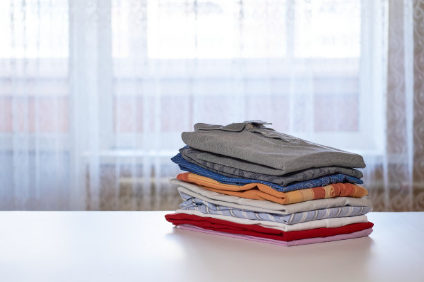 叠衣服。在熨衣板上叠好衬衫图片下载