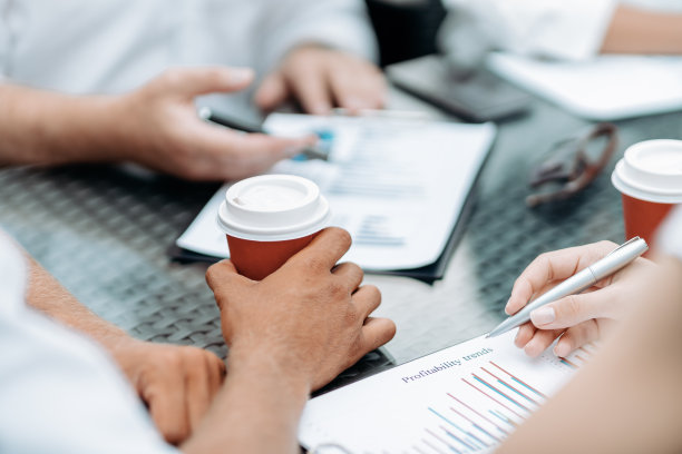 商人端着外卖咖啡讨论财务文件图片下载