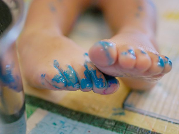 特写小婴儿的脚趾和脚趾甲，2岁，正在被涂，凌乱，肮脏图片下载