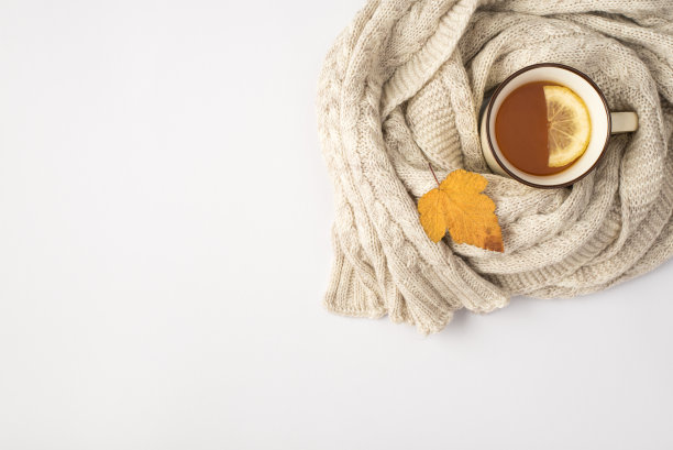 顶视图照片的茶与柠檬黄色的秋天叶子和围巾在孤立的白色背景与copyspace图片下载