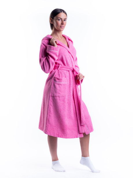 一个穿着浴袍的女人，站在一个孤立的白色背景下，脸上挂着微笑。图片下载