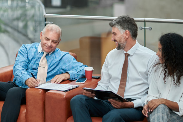 一位商人坐在办公室大厅里签署一份文件图片下载