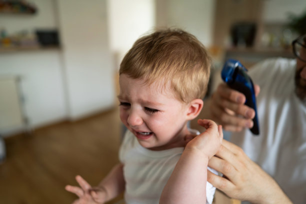 一个小男孩在理发时哭泣的特写镜头图片下载