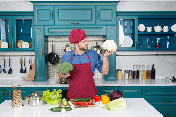 厨师食谱。用传统食谱做晚餐。准备吃饭。健康食品。专业的厨房。传统的美食。男人在厨房概念。新鲜的蔬菜。厨房里漂亮的厨师图片下载